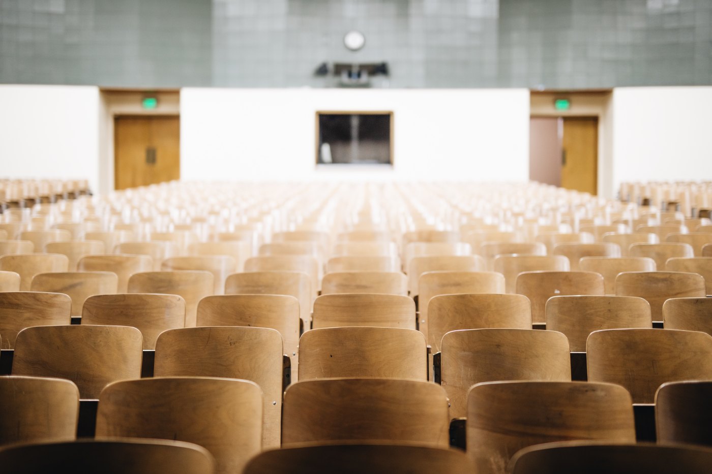 empty chairs in college auditorium style business ethics class discussing the Effectiveness of Professional Ethics Education studies can be to the student. Photo by Nathan Dumlao on Unsplash